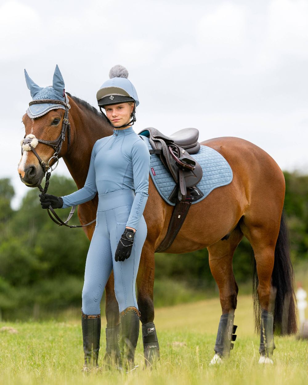 Ice Blue coloured LeMieux Young Rider Base Layer on sky background