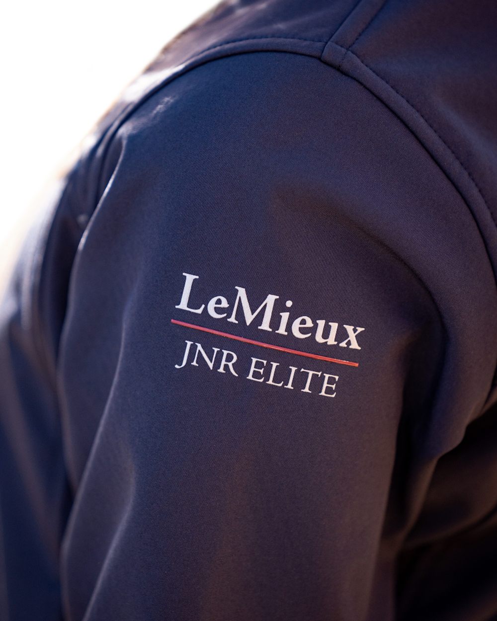 Navy coloured LeMieux Young Rider Elite Soft Shell Jacket on white background