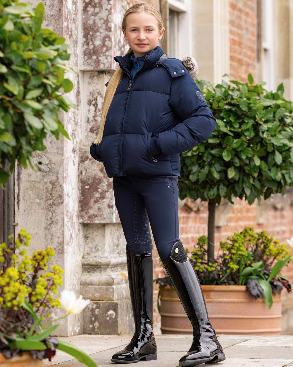 Navy coloured LeMieux Young Rider Freya Pro Breeches on wall background