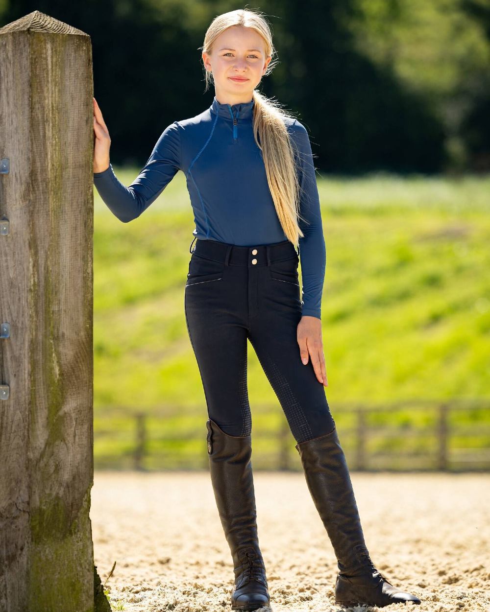 Navy coloured LeMieux Young Rider Freya Pro Breeches on green background