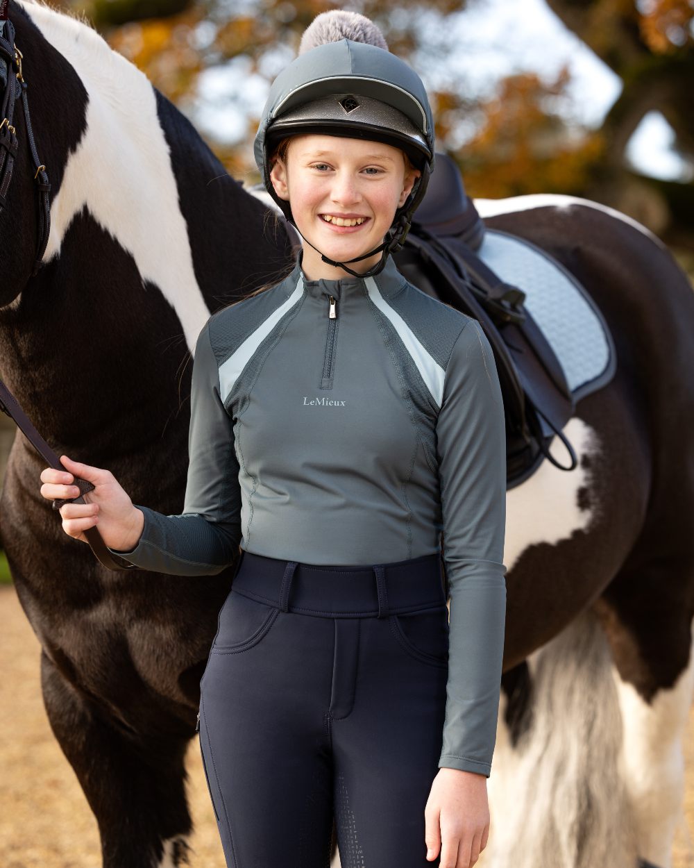 Petrol Coloured LeMieux Young Rider Mia Mesh Base Layer On A Blurry Background