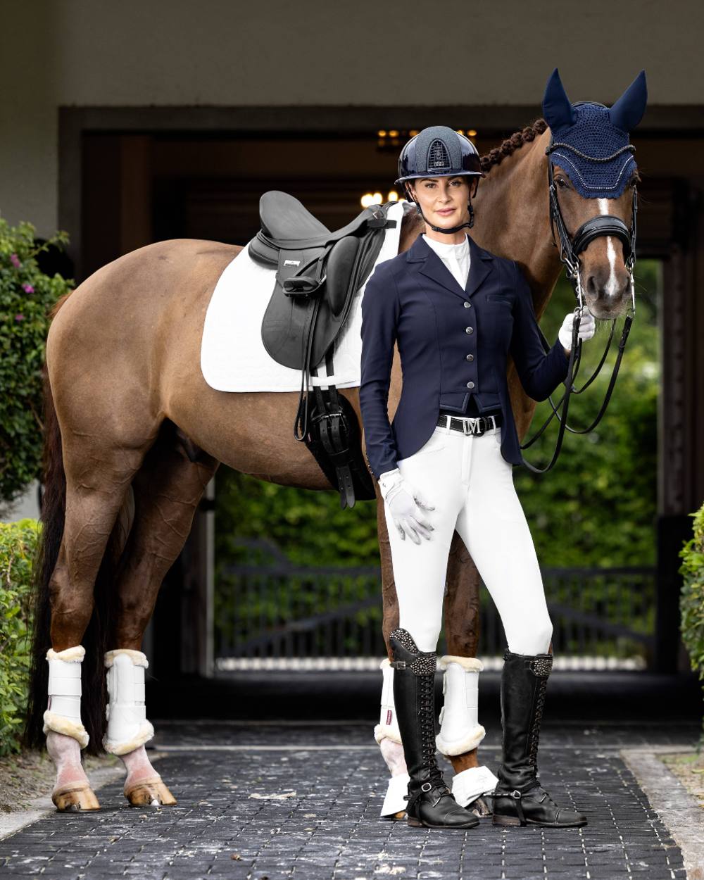Navy coloured LeMieux Zoe Show Jacket on blurry building background