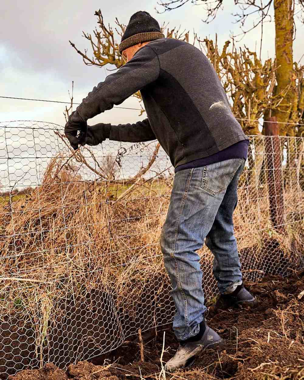 Black Coloured Muck Boots Mens Woody Sport Ankle Boots On A Field Background