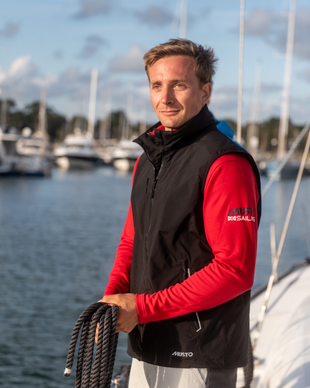 Black Coloured Musto Corsica Gilet 2.0 On A Sea Background