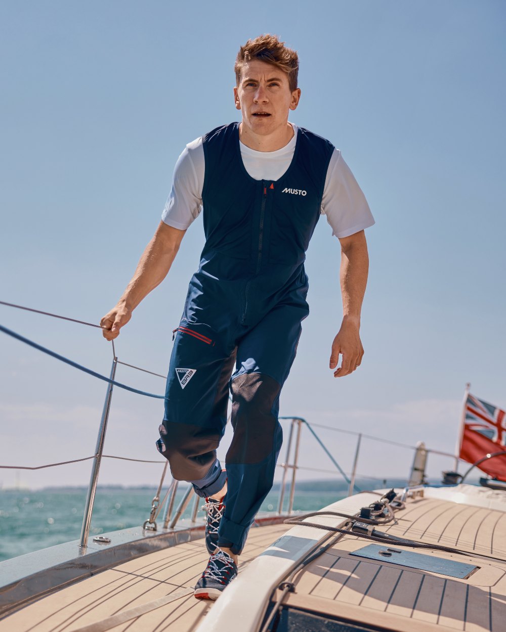 True Navy Coloured Musto Mens Br3 Sport Salopette on Boat Background
