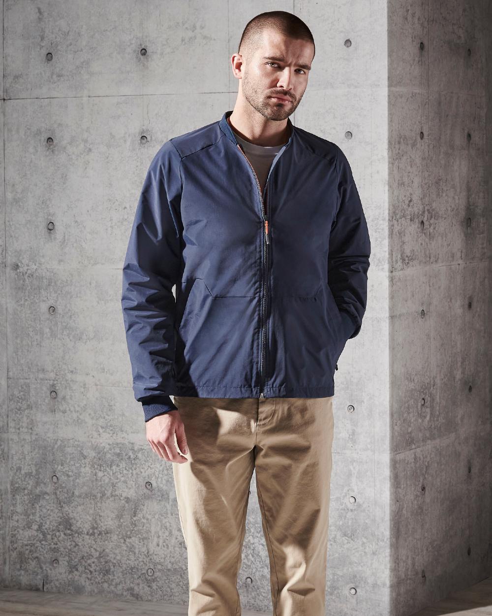 Navy Coloured Musto Mens Land Rover Technical Bomber On A Wall Background 
