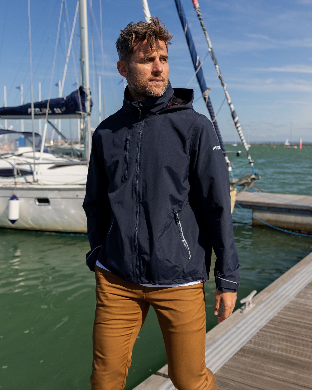 True Navy Coloured Musto Mens Sardinia Jacket on Beach Background