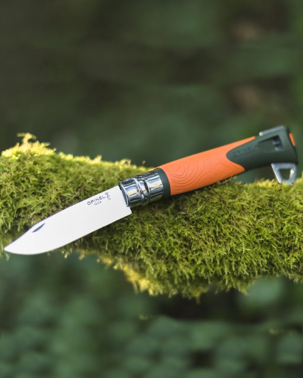 Orange Coloured Opinel No. 12 Explore Knife with Tick Remover On A forest Background