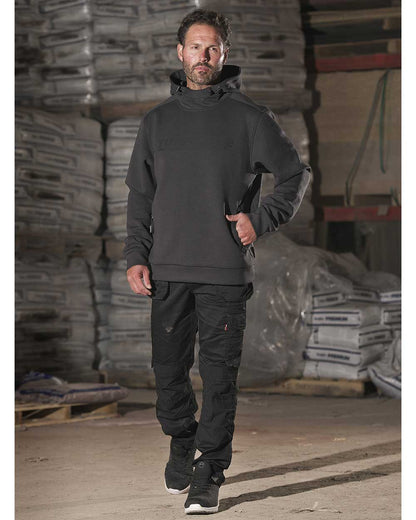 Man in warehouse wearing TuffStuff Extreme Work Trousers in Black 