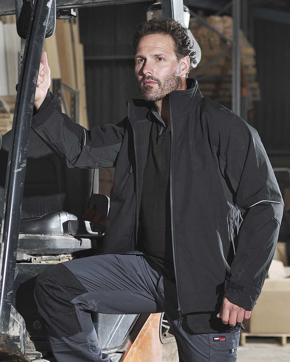 Man with forklift truck wearing TuffStuff Stanton Softshell Jacket in black 