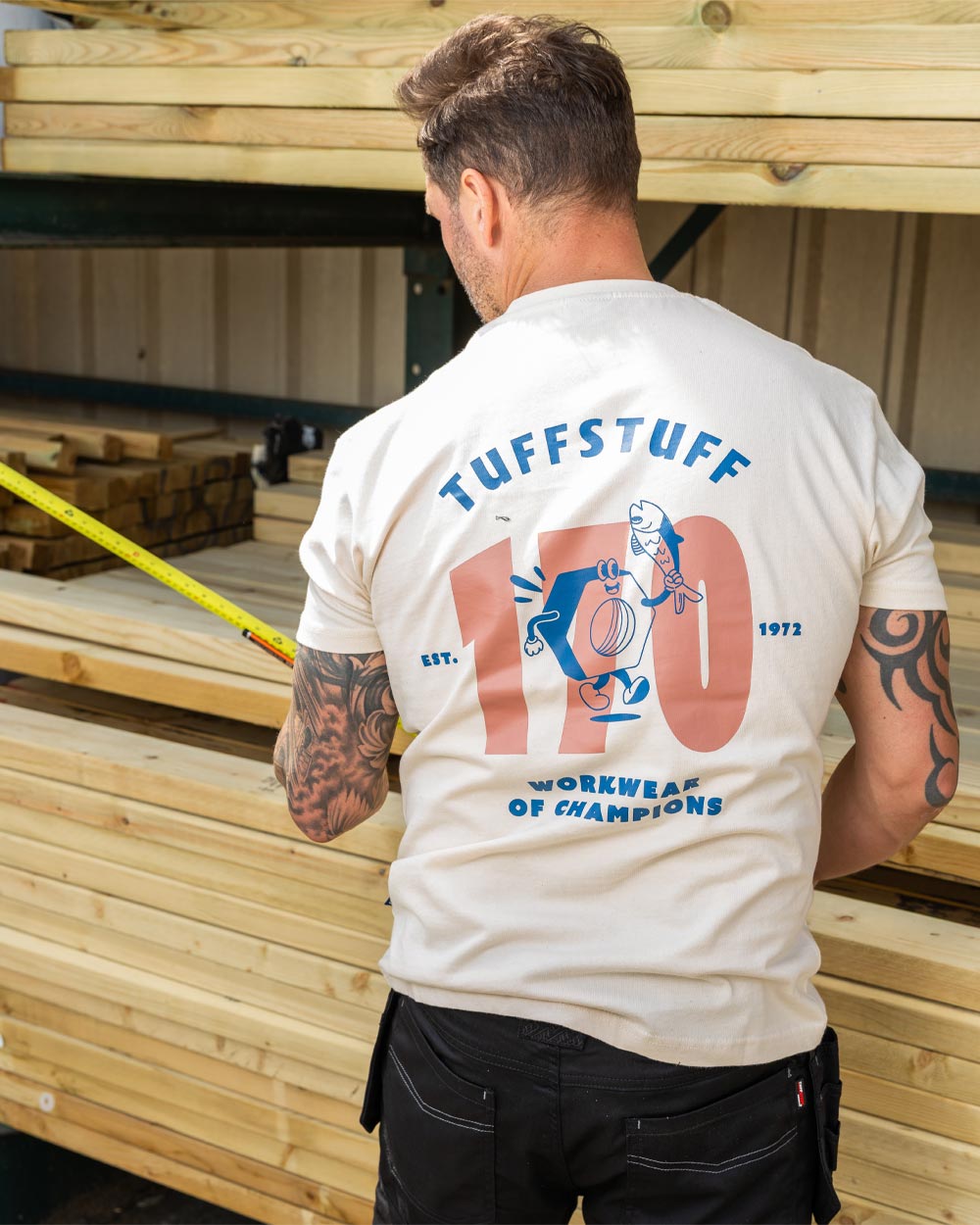 Male model wearing white coloured TuffStuff Icon T-Shirt with measuring tape in hand 