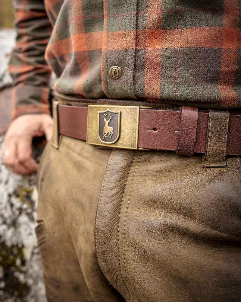 Close-up of a Deerhunter leather belt with stag buckle worn with country clothing