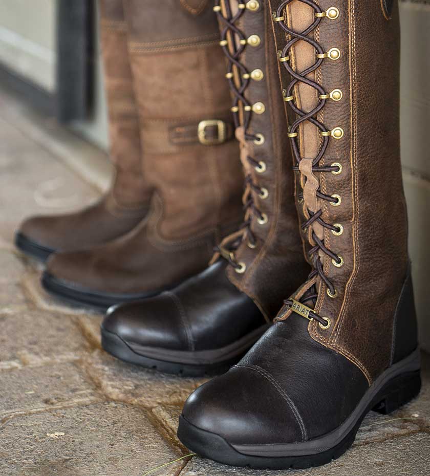 Country high leg boots Knee high lace up leather boots on stone floor.