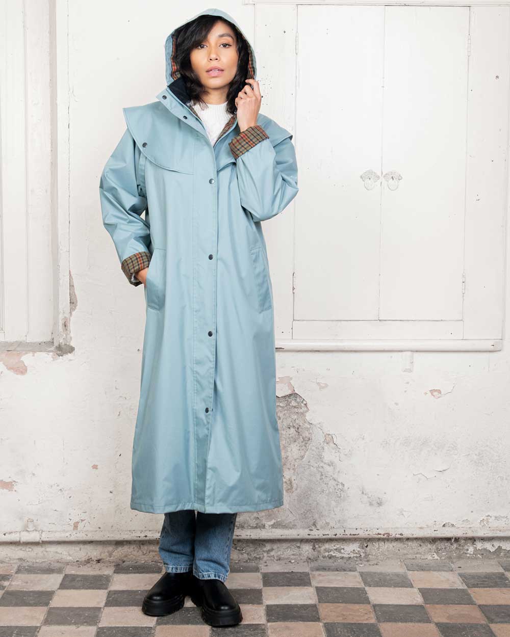 Smokey Blue coloured Jack Murphy Malvern Ladies Waterproof Bush Coat on wall background 