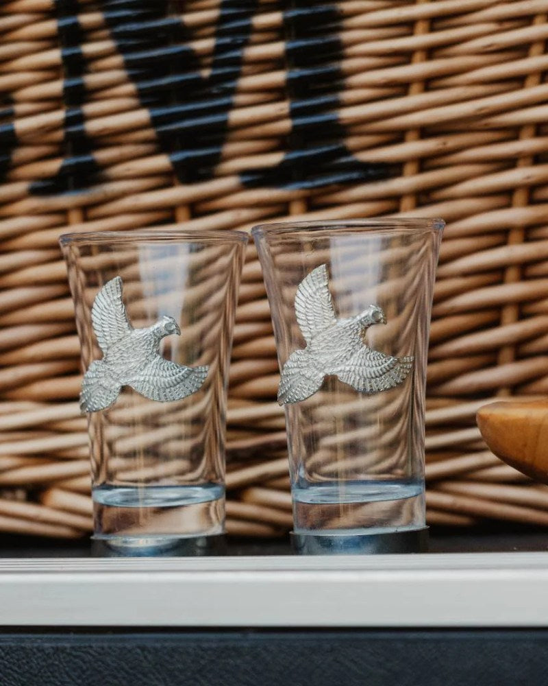 Two Bisley shot glasses with pheasant design displayed on a shelf