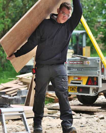 Joiner carrying chip board wearing Cargo trousers TuffStuff X Motion Work Trousers