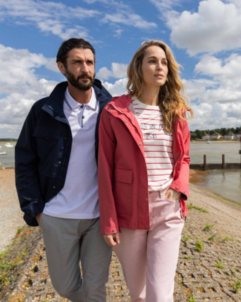 Male and female model both walking together wearing Musto jackets, one pink and one navy. 