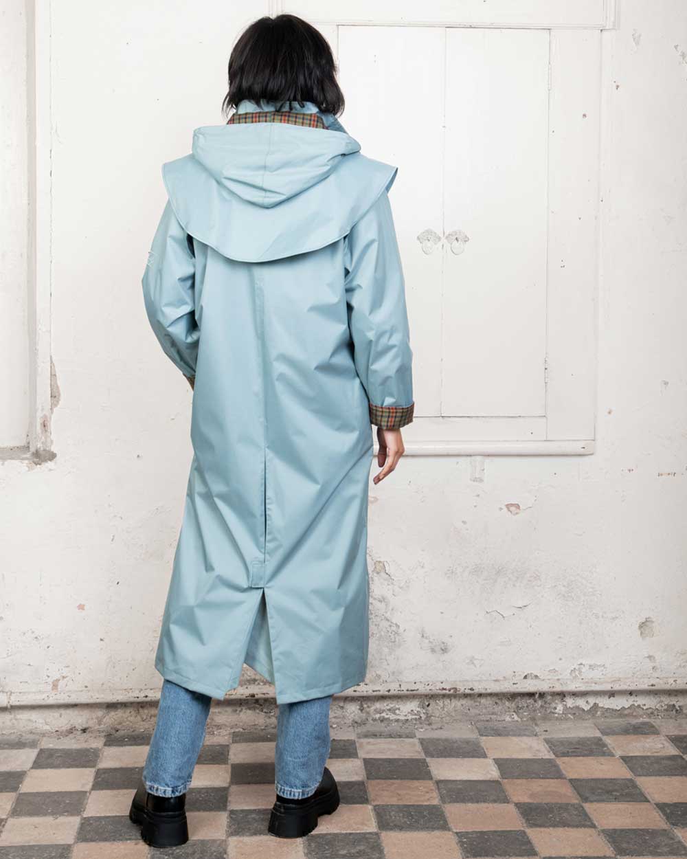 Smokey Blue coloured Jack Murphy Malvern Ladies Waterproof Bush Coat on wall background 