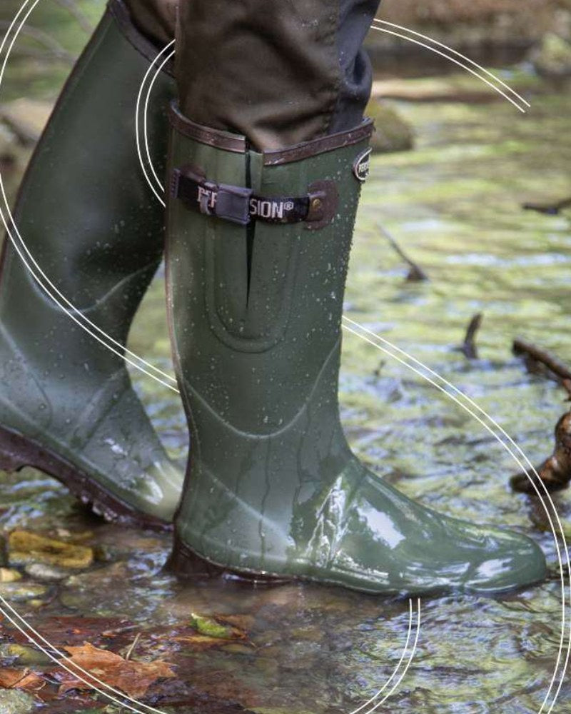 Person wearing green Percussion wellington boots while walking through a shallow stream