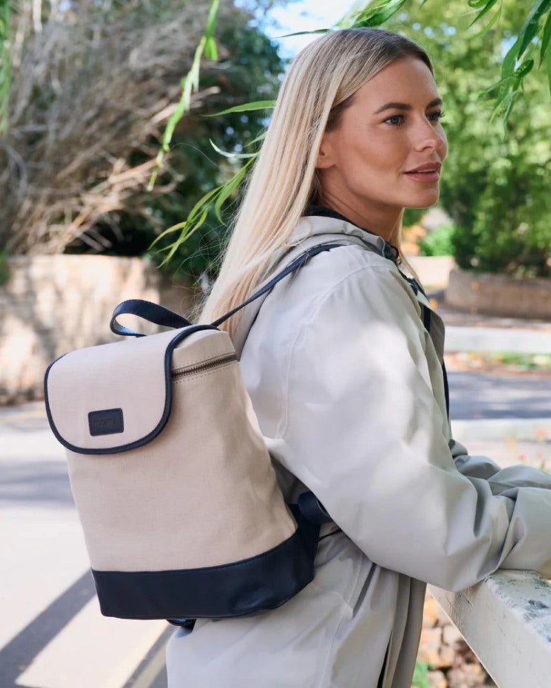 Woman wearing a Dubarry canvas backpack with leather trim outdoors in a park setting