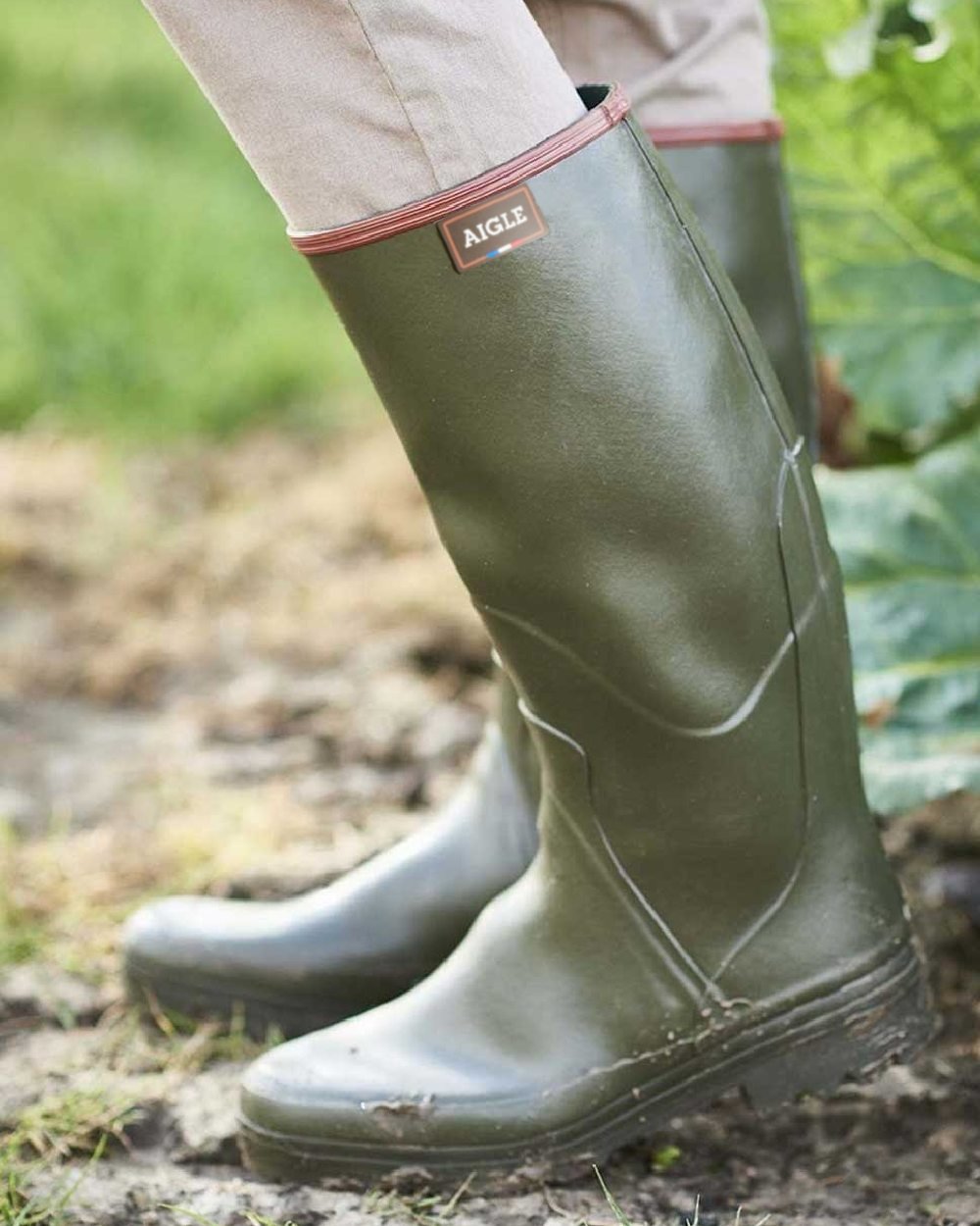 Khaki coloured Aigle Chambord Pro 2 Wellington Boots on mud background 