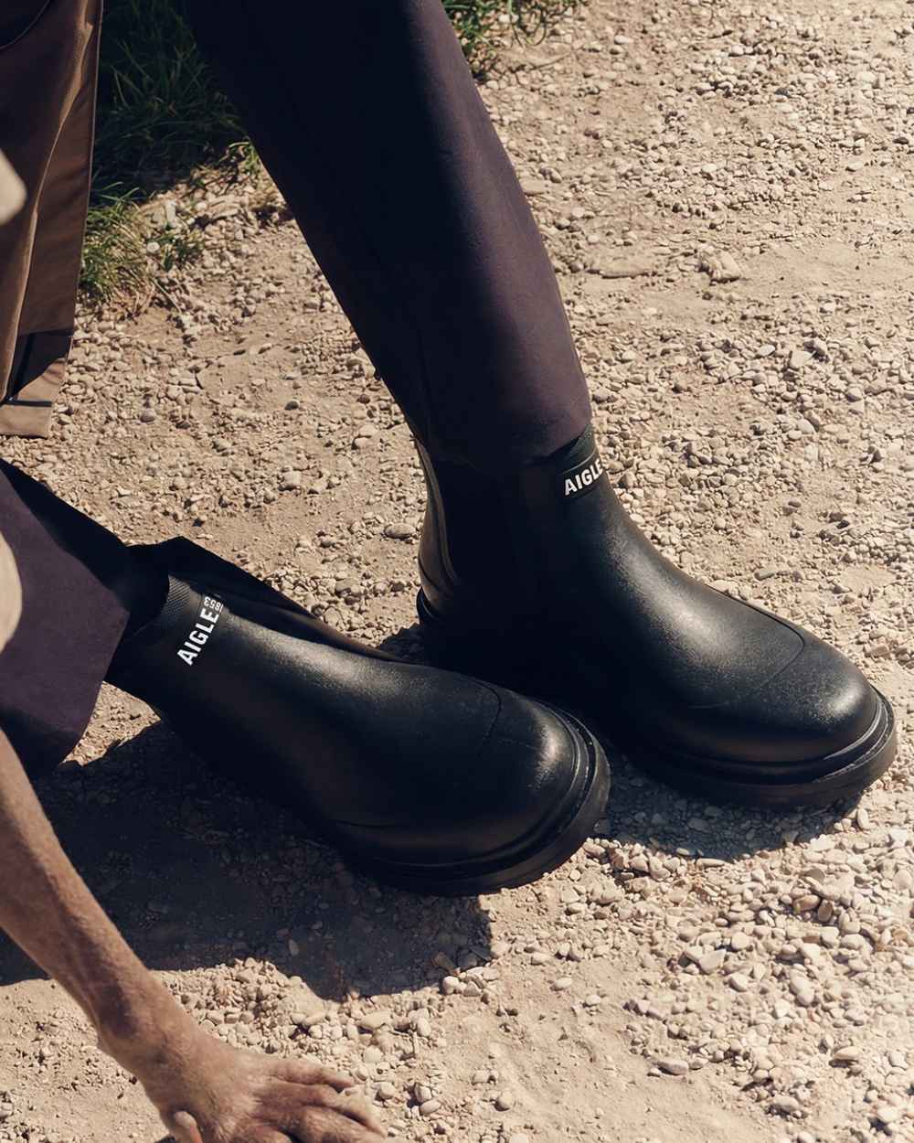 Noir coloured Aigle Chelsea Rain Ankle Boots on soil background 