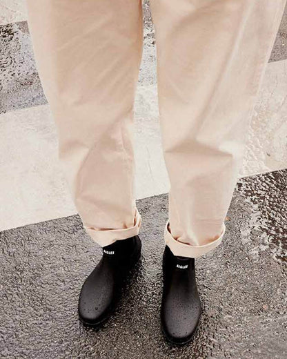 Noir coloured Aigle Mens Carville M2 Ankle Wellingtons on street background 