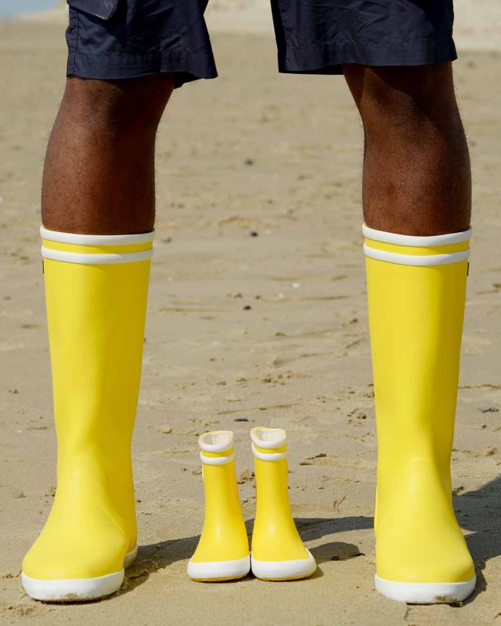 Jaune Blanc coloured Aigle Mens Goeland 2 Seaside Wellingtons on sand background 