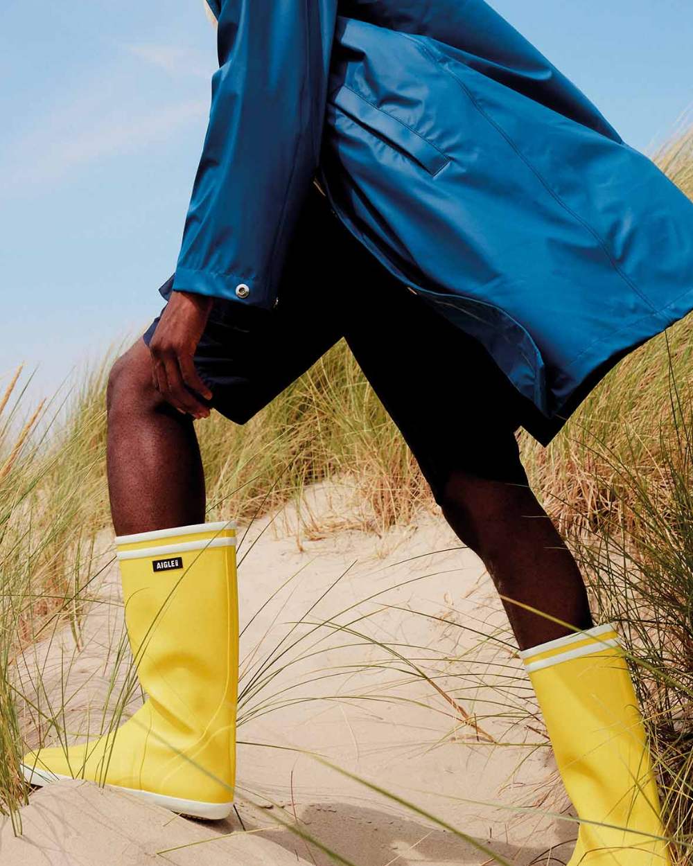 Jaune Blanc coloured Aigle Mens Goeland 2 Seaside Wellingtons on sand background 