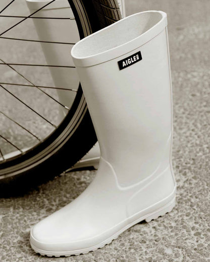 Sable coloured Aigle Womens Eliosa Wellingtons on street background 