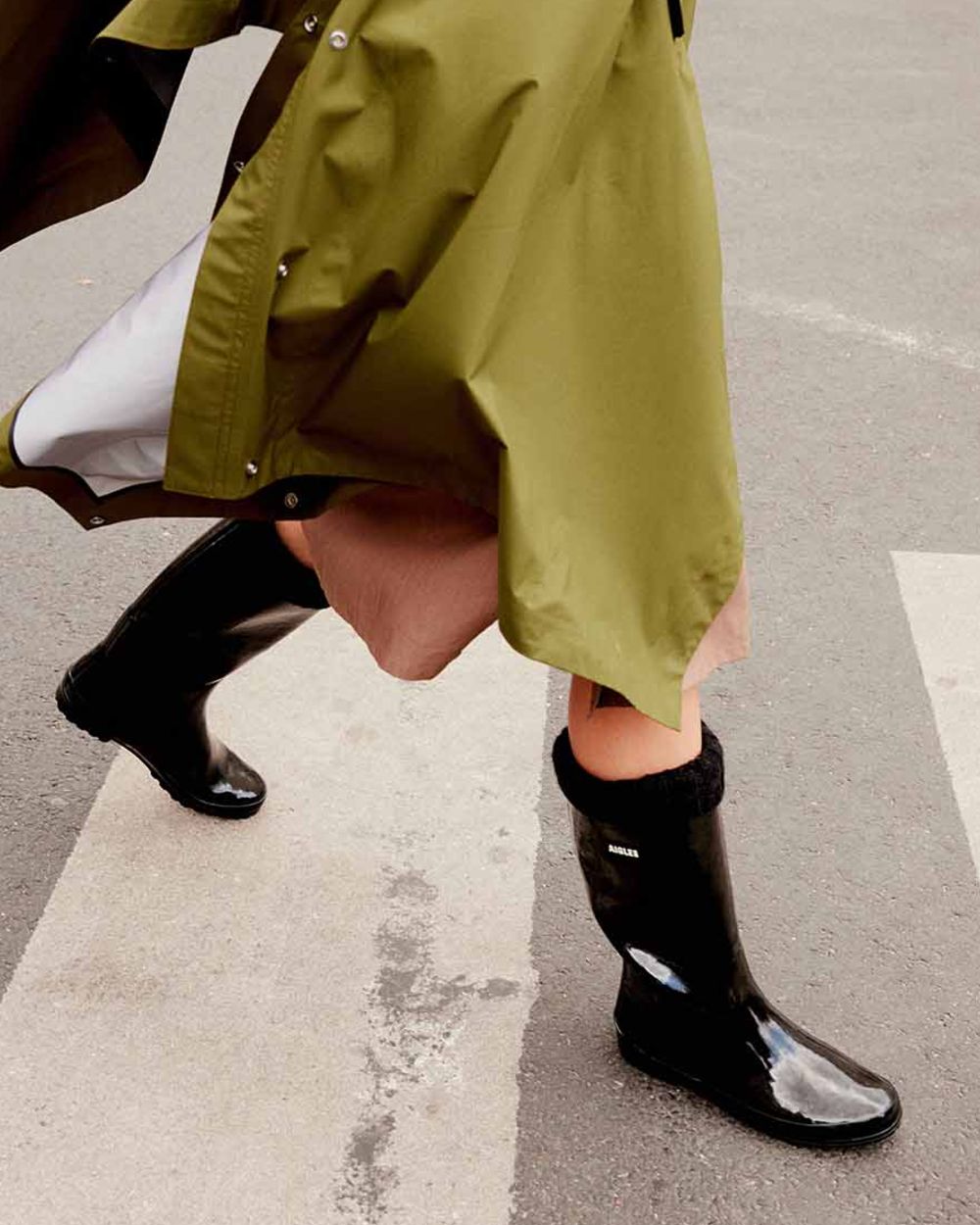 Noir coloured Aigle Womens Eliosa Fur Lined Wellingtons on street background 