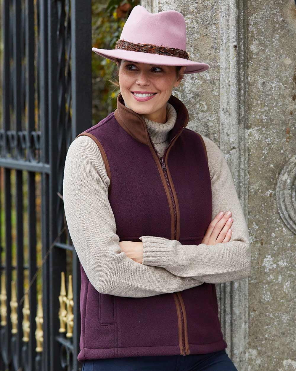 Merlot Coloured Alan Paine Aylsham Ladies Fleece Gilet on gate background 