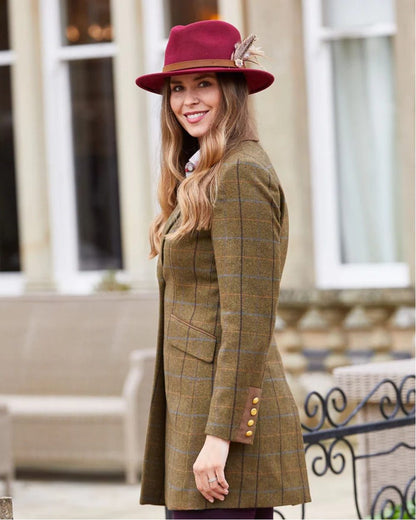 Hazel coloured Alan Paine Combrook Ladies Mid Thigh Coat on house background 