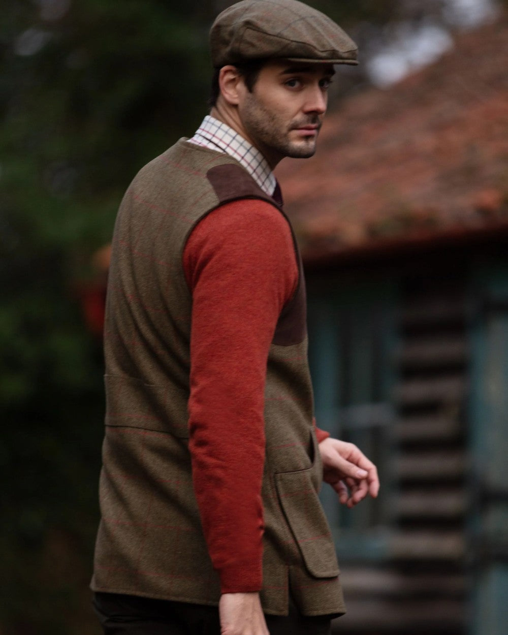 Sage coloured Alan Paine Combrook Tweed Shooting Waistcoat on blurry background 