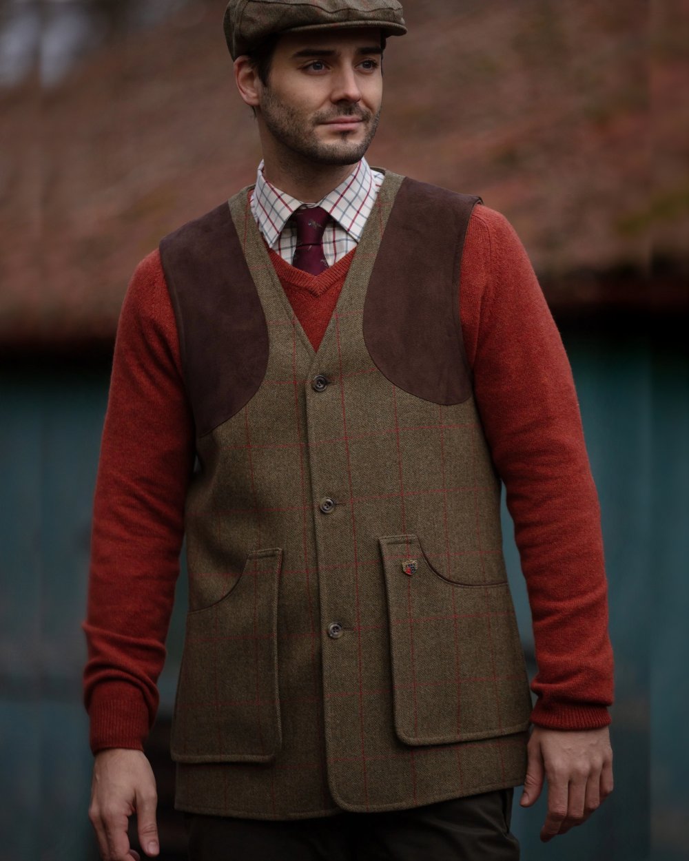 Sage coloured Alan Paine Combrook Tweed Shooting Waistcoat on blurry background 