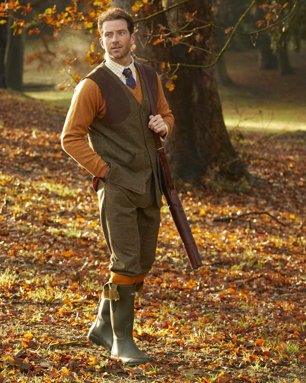 Teak coloured Alan Paine Combrook Tweed Shooting Waistcoat on forest background 