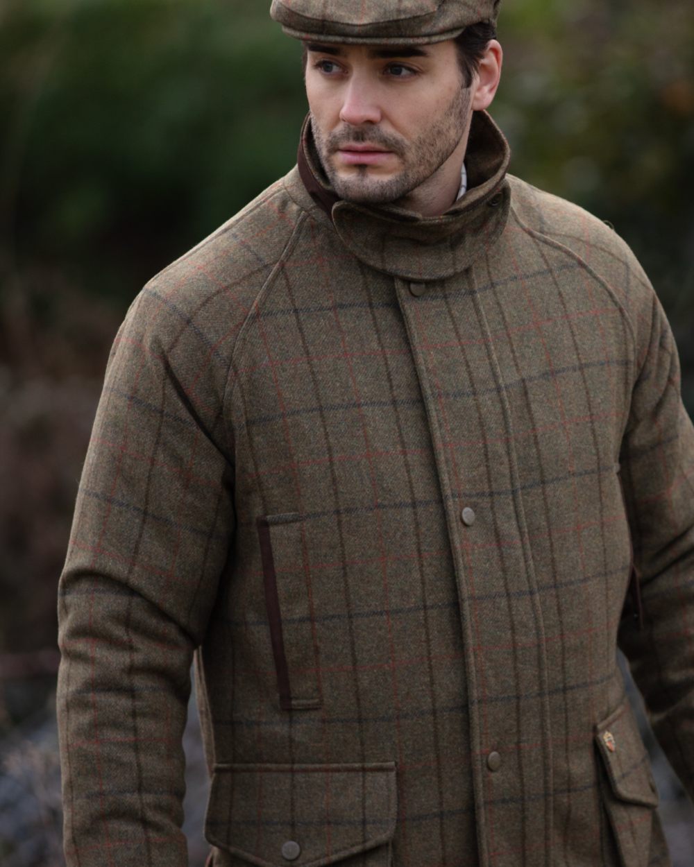 Thyme coloured Alan Paine Combrook Tweed Waterproof Coat on forest background 