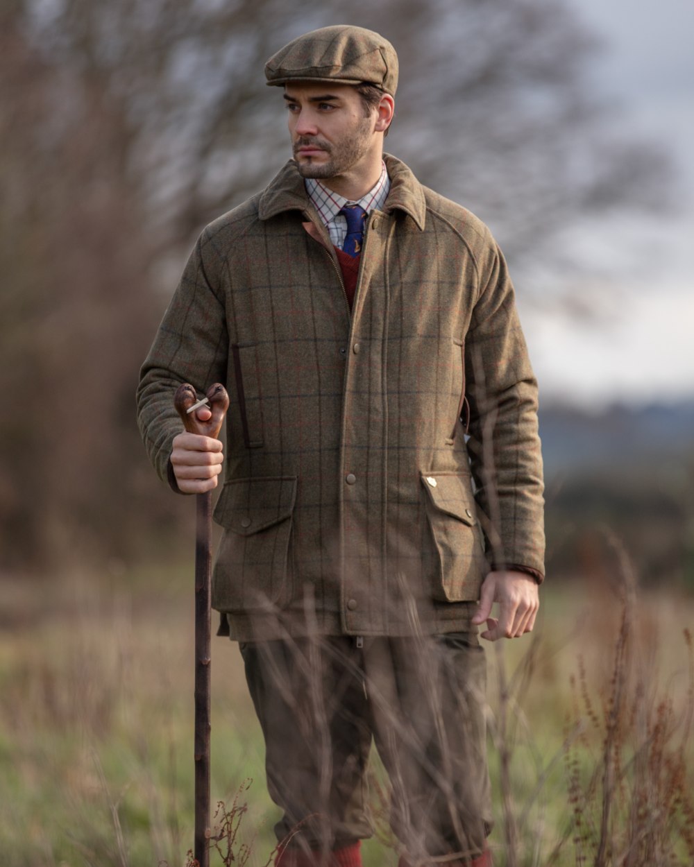 Thyme coloured Alan Paine Combrook Tweed Waterproof Coat on forest background 