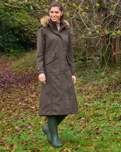 Olive coloured Alan Paine Ladies Dunswell Waterproof Long Coat on forest background 