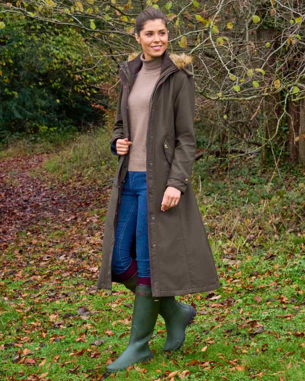 Olive coloured Alan Paine Ladies Dunswell Waterproof Long Coat on forest background 