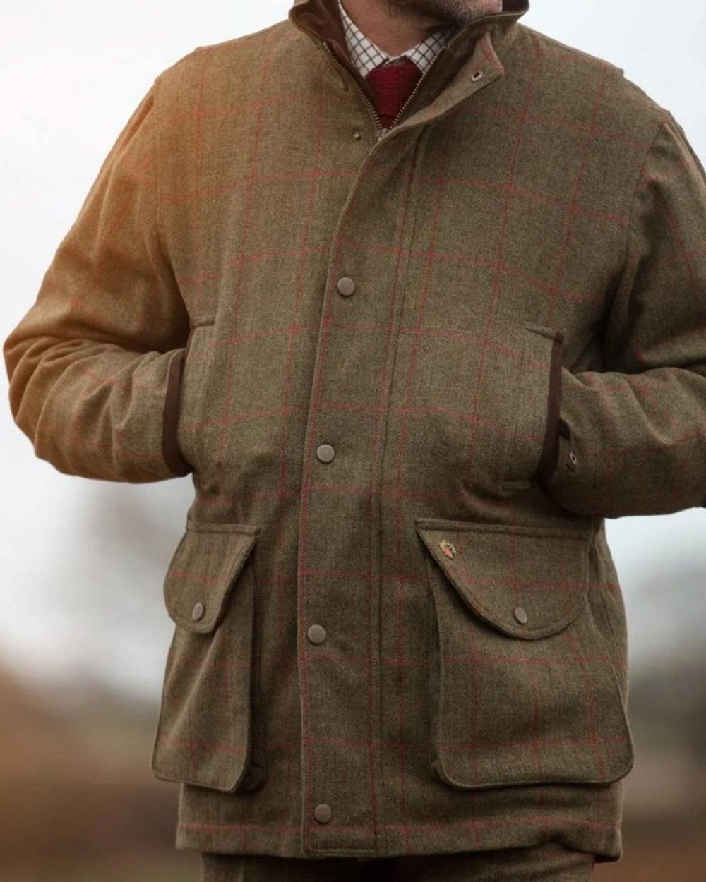 Sage coloured Alan Paine Mens Combrook Field Coat on blurry background 