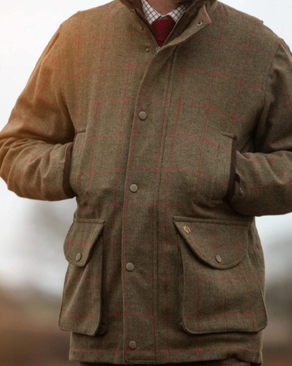 Sage coloured Alan Paine Mens Combrook Field Coat on blurry background 