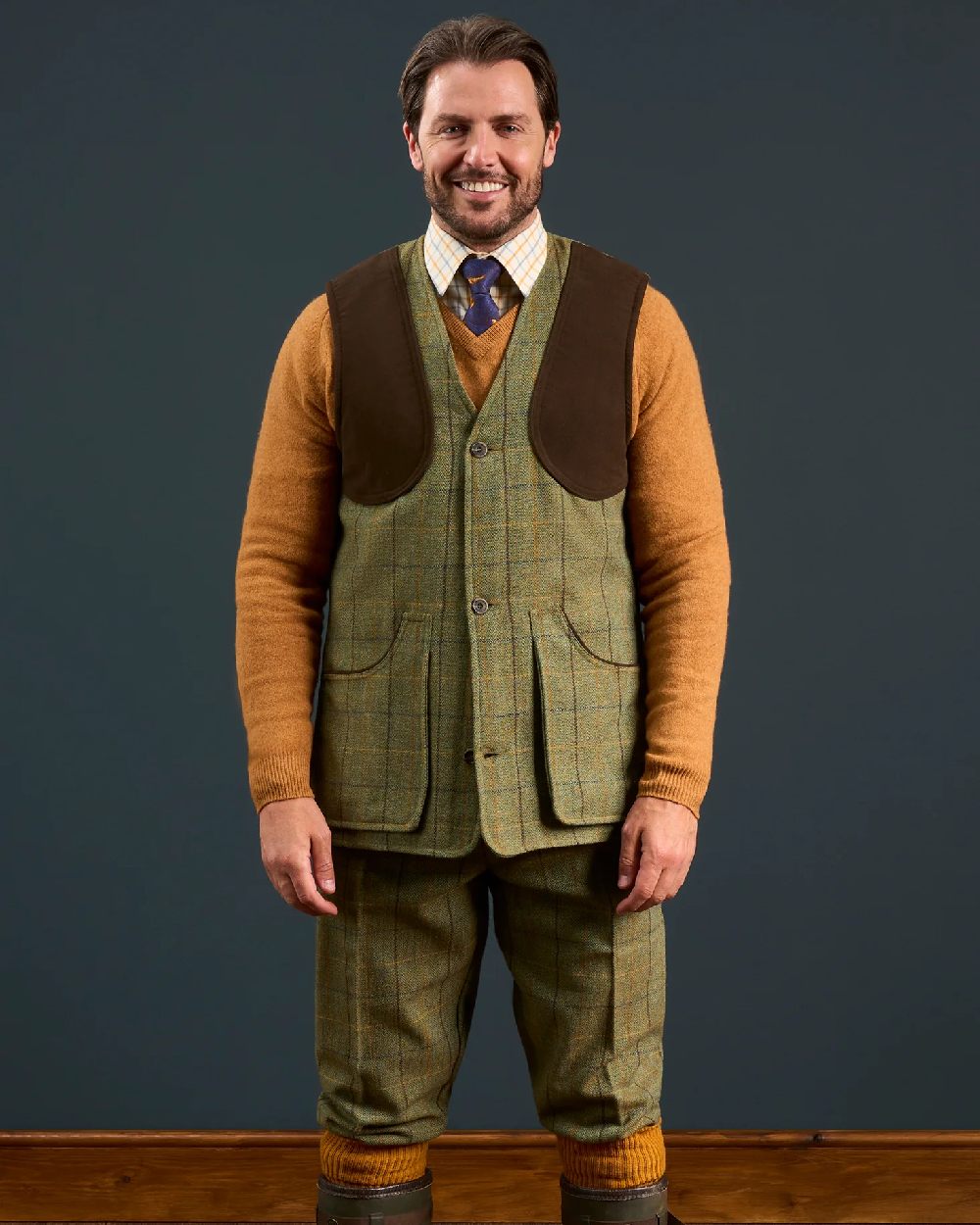 Dark Moss coloured Alan Paine Rutland Tweed Shooting Waistcoat on indoor background 