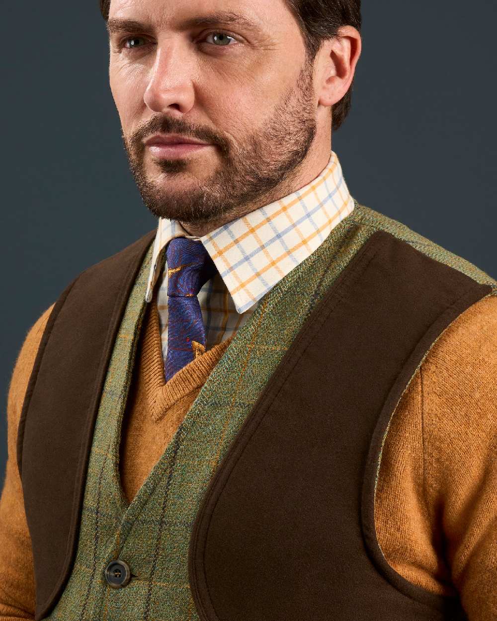 Dark Moss coloured Alan Paine Rutland Tweed Shooting Waistcoat on indoor background 