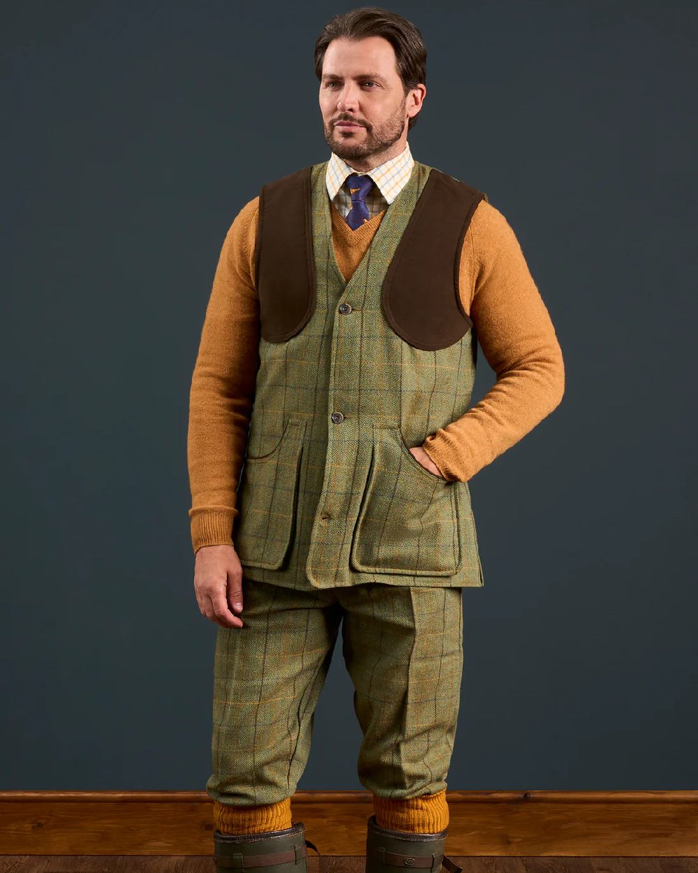 Dark Moss coloured Alan Paine Rutland Tweed Shooting Waistcoat on indoor background 