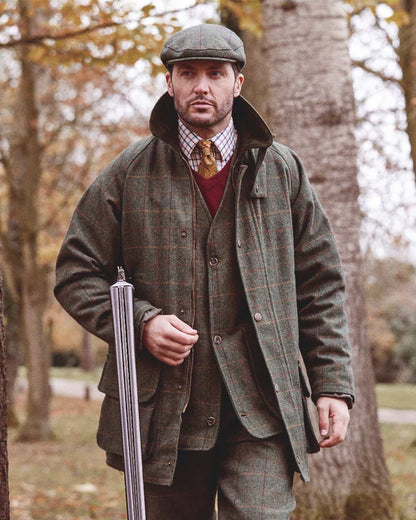 Fern coloured Alan Paine Rutland Tweed Shooting Waistcoat on forest background 