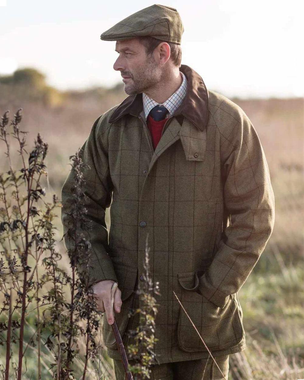 Lichen coloured Alan Paine Rutland Waterproof Tweed Shooting Coat on forest background 