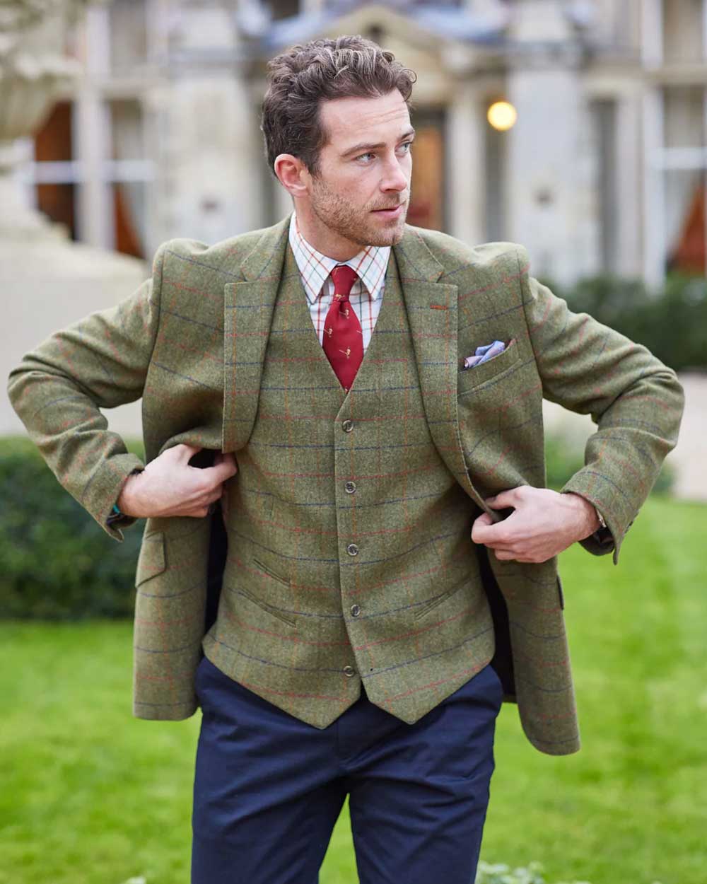 Meadow Coloured Alan Paine Surrey Mens Tweed Lined Waistcoat on blurry house background 