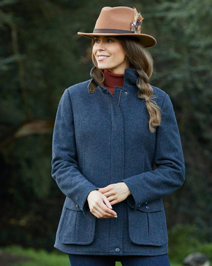 Blue coloured Alan Paine Surrey Tweed Coat on tree background 