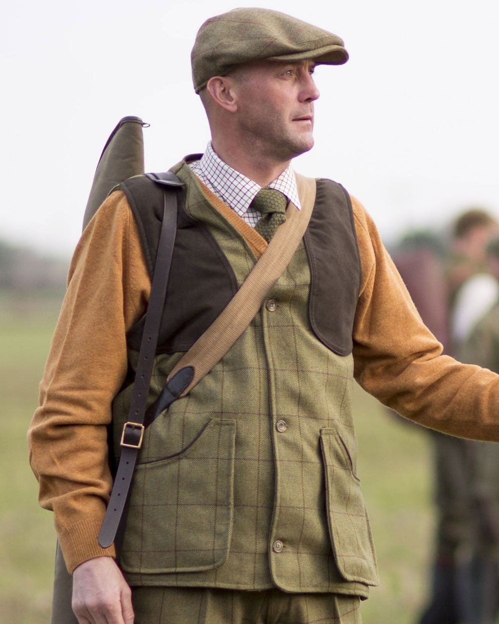 Lichen coloured Alan Paine Rutland Tweed Shooting Waistcoat on blurry background 
